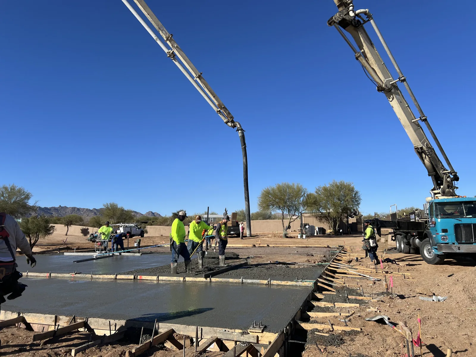 Concrete pump truck placing a slab while the crew screeds it in Phoenix, AZ